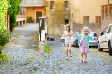Fototapeta na wymiar Two adorable little sisters having fun together on warm and sunny summer day