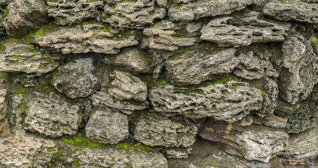 Texture of old stone wall covered by moss