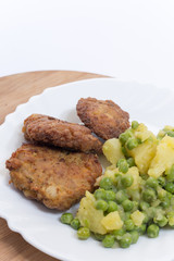 Homemade burgers served with potatoes and green peas