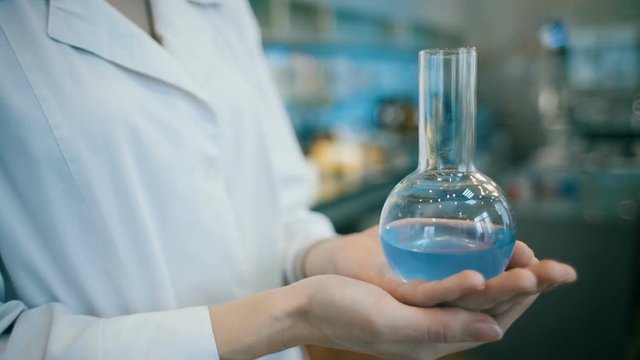 Woman in a laboratory holding flask 