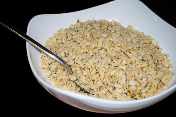 Puffed wheat bowl isolated on black background
