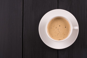 Cappuccino with cinnamon in a white cup. Coffee on Black Wooden Table