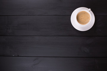 Cappuccino with cinnamon in a white cup. Coffee on Black Wooden Table