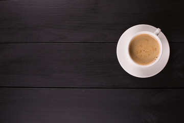 Cappuccino with cinnamon in a white cup. Coffee on Black Wooden Table