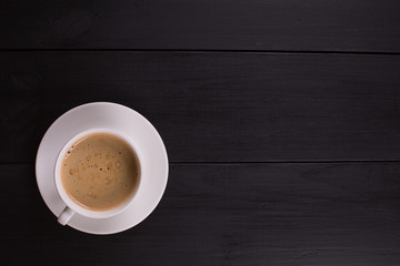 Cappuccino with cinnamon in a white cup. Coffee on Black Wooden Table