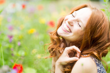 schöne lachende Frau in der Blumenwiese