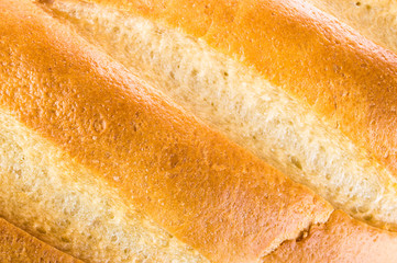 White wheaten long loaf on a white background. Bread close-up.
