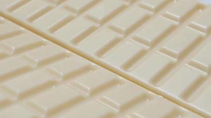 White milk chocolate blocks in a row sweet background slow tilt 4K 2160p 30fps UltraHD video - Junk food background of white chocolate bars tilting 4K 3840X2160 UHD footage 