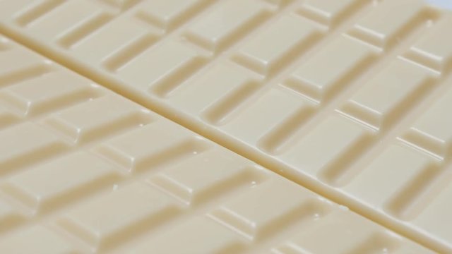 White milk chocolate blocks in a row sweet background slow tilt 4K 2160p 30fps UltraHD video - Junk food background of white chocolate bars tilting 4K 3840X2160 UHD footage 