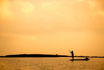 silhouette fisherman is fishing in the lake