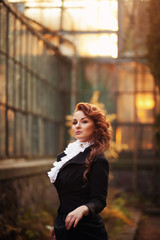 Fototapeta premium Sweet red-haired girl in a black vintage clothing