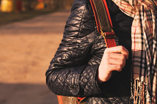 Young woman hand on her backpack, warm toning