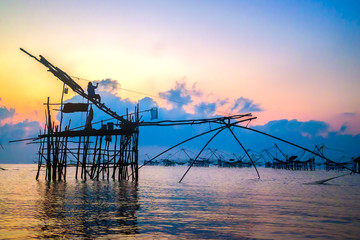 Fototapeta na wymiar Fisherman at square dip net and colorful sky at Pakpra, phattalu