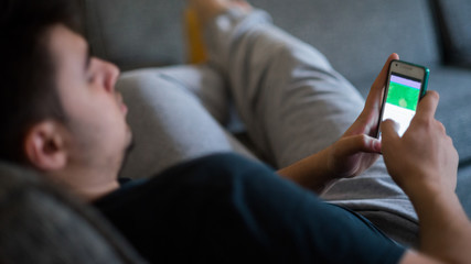 Boy is using a smartphone. Modern mobile phone in hand.