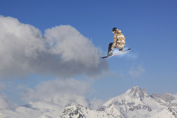 Flying snowboarder on mountains. Extreme sport.