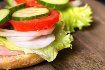 Sandwich with salad and other vegetables on old gray boards