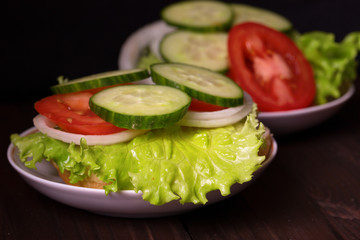 Bread with salad and other vegetables lies on a saucer