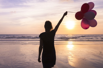 Girl with helium balloons in hand, concept about happiness