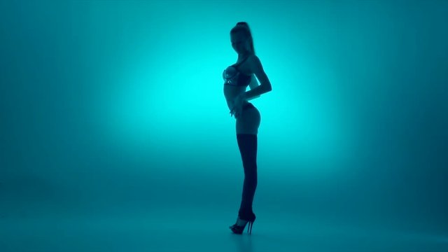attractive young woman dancing, studio dark background