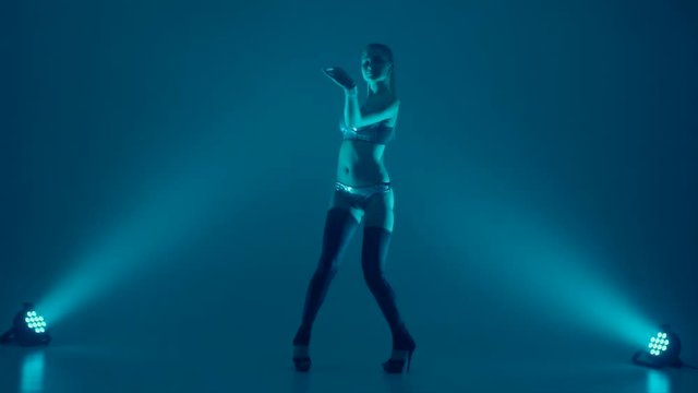 attractive young woman dancing, studio dark background