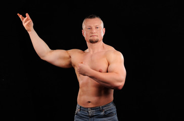 Fototapeta na wymiar Muscular male posing on black background