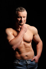 Fototapeta premium Muscular male posing on black background