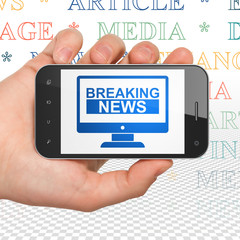 News concept: Hand Holding Smartphone with Breaking News On Screen on display