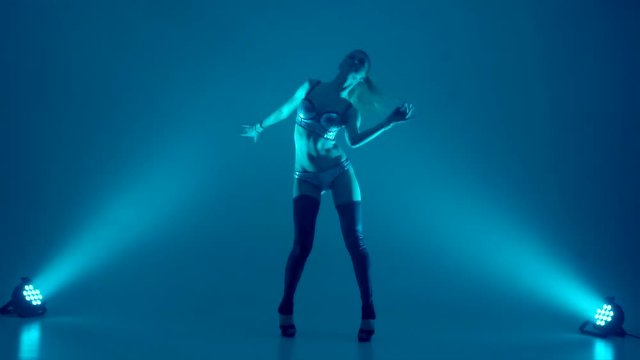 attractive young woman dancing, studio dark background