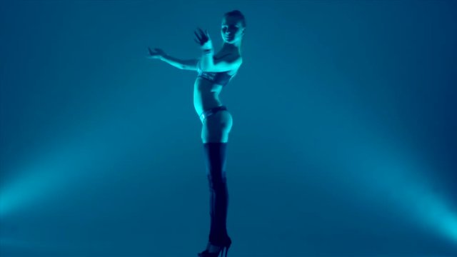 attractive young woman dancing, studio dark background
