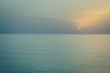 Sunset over the sea. Silhouette of boats on the horizon