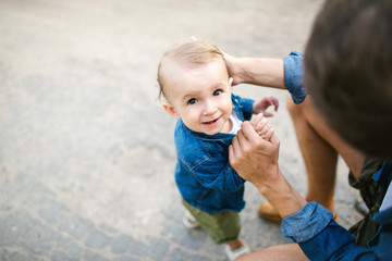 Young father holding cute son's hand and smiling