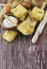 Uncooked pasta with flour on the table, selective focus