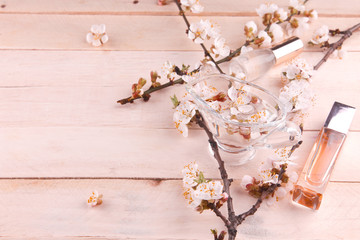 Two bottles of perfume surrounded by apricot blossom