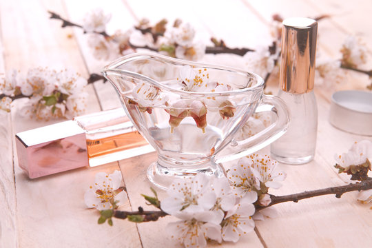 Two bottles of perfume surrounded by apricot blossom
