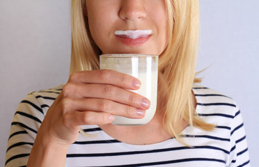 Funny young woman mustache from yogurt (milk, mustache). Dairy products concept