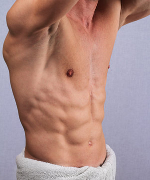 Muscular male torso, chest and armpit hair removal close up. Male Brazilian Waxing treatment