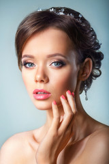 Naklejka premium portrait of the beautiful young girl in an image of the bride with ornament in hair.Beautiful Spa Woman Touching her Face. Youth and Skin Care Concept.
