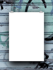 Close-up of one blank frame hanged by clips against blue rusty metal shutter background