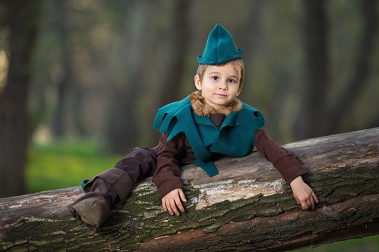 Cute little boy dressed as a Robin Hood playing in the woods