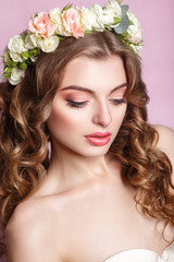 Beautiful young girl with a floral ornament in her hair.Beautiful Woman Touching her Face. Youth and Skin Care Concept.Nymph. Portrait of Genuine Gorgeous Woman in Wreath of Flowers