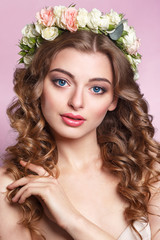 Naklejka premium Beautiful young girl with a floral ornament in her hair.Beautiful Woman Touching her Face. Youth and Skin Care Concept.Nymph. Portrait of Genuine Gorgeous Woman in Wreath of Flowers