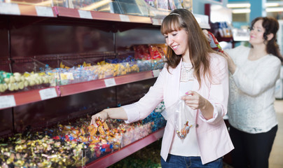 Happy female buyers selecting traditional candies