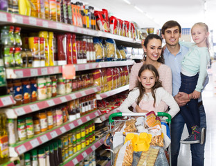 parents with two kids and purchases in shopping cart