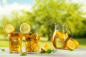 Cups of ice tea with trees on background