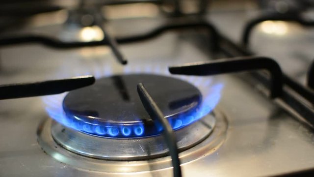 Closeup of flames on a ring burner on the gas stove in the kitchen. Flames on burner.