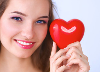 Portrait of beautiful happy woman holding a symbol heart. 