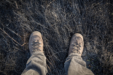 Boots on burnt grass