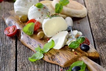 Mozzarella - Käsebrotzeit mit Kirsch-Tomaten und Basilikum rustikal serviert - Mozzarella cheese...