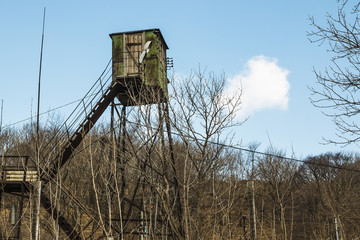 old observation tower on the background of trees without leaves
