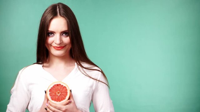 Woman holds half of grapefruit citrus fruit in hand 4K